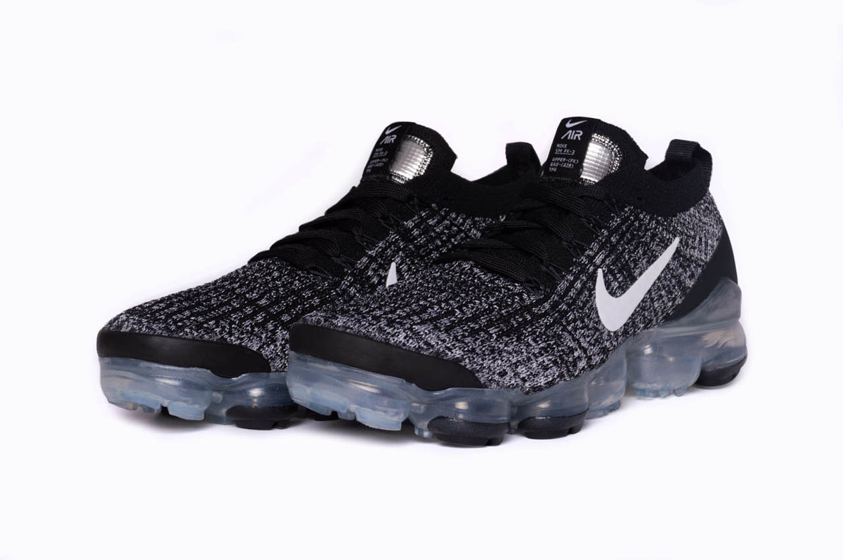 The Nike Air VaporMax Flyknit 3 from a 270 degree angle. This angle showcases the signature air pods along with the hallmark Nike swoosh along the side.